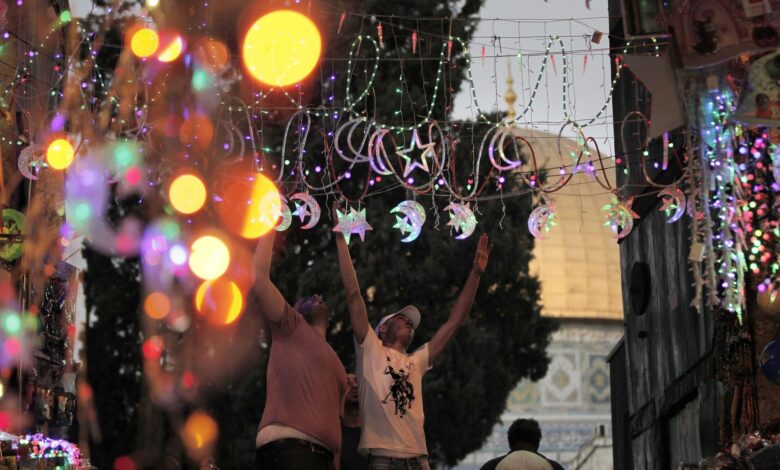 خلفية لزينة رمضان و مجموعة من الشباب يعلقونها في الطريق.