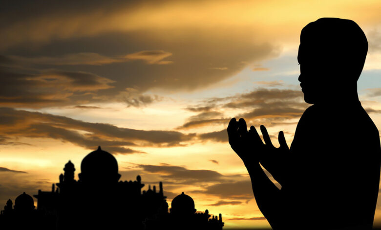 خلفية دينية لشاب يرفع يده بالدعاء و مسجد.