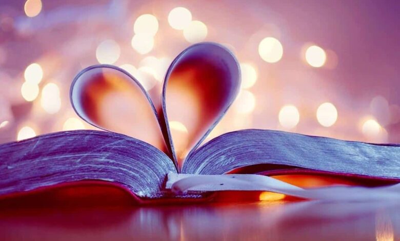 خلفية رومانسية لكتاب وردي مطوي صفحاته على شكل قلب.