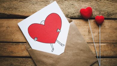 صورة جميلة لظرف يوجد به ورقة مرسوم عليها رجل يحمل قلب أحمر حلو