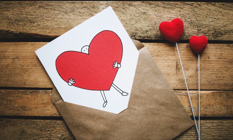 صورة جميلة لظرف يوجد به ورقة مرسوم عليها رجل يحمل قلب أحمر حلو