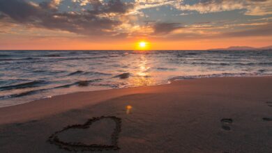 صورة جميلة لقلب مرسوم علي الرمل بجانب البحر