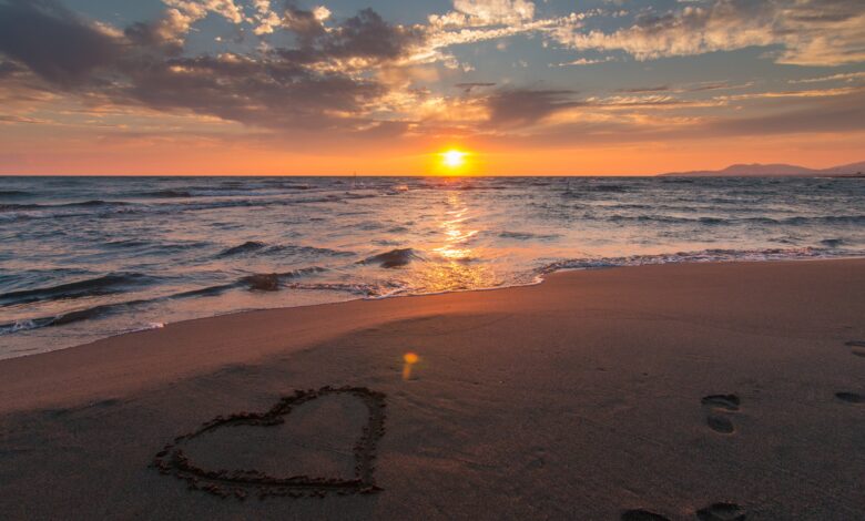 صورة جميلة لقلب مرسوم علي الرمل بجانب البحر