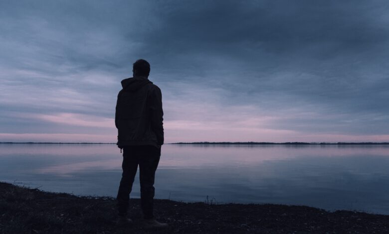 صورة تعيسة جداً تظهر رجل يقف ينظر أمامه في حالة من الحزن